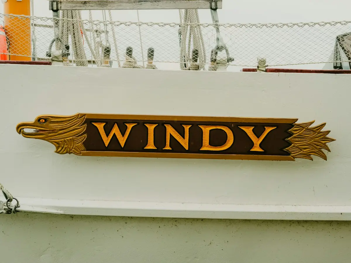 Placa entalhada em madeira com o nome WINDY em letras douradas